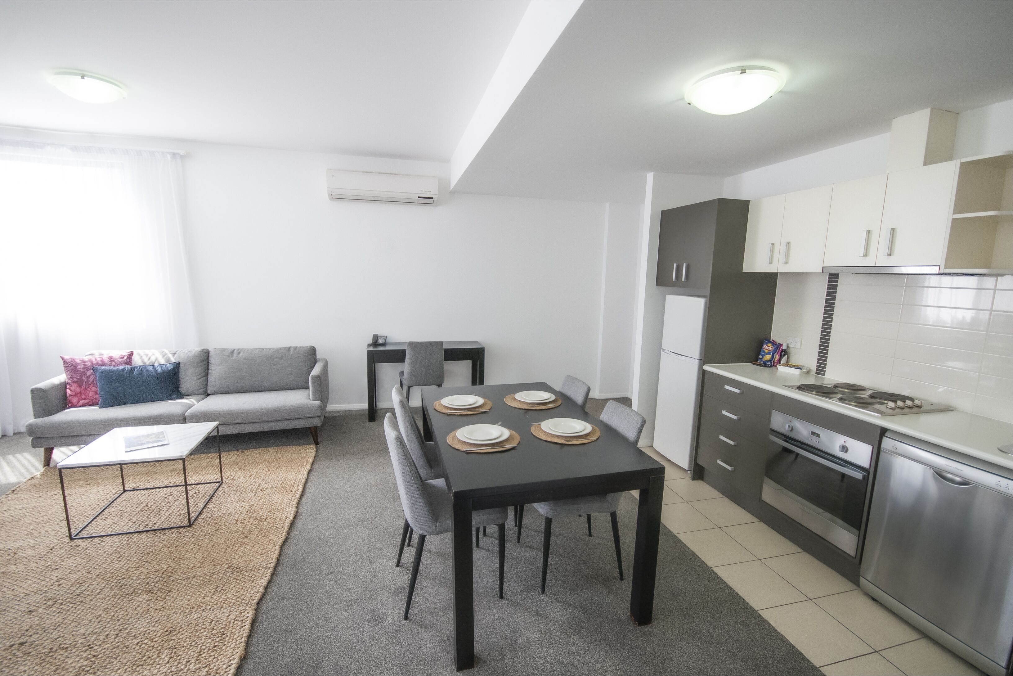 Une cuisine moderne avec un coin repas, un canapé et une table basse.