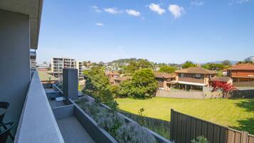 Un balcón con vista a una zona residencial, con casas y vegetación.