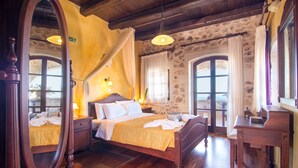 A traditional bedroom with a wooden bed, a nightstand, a dresser, and a mirror. - Samonas Traditional Villas (Apokoronas)
