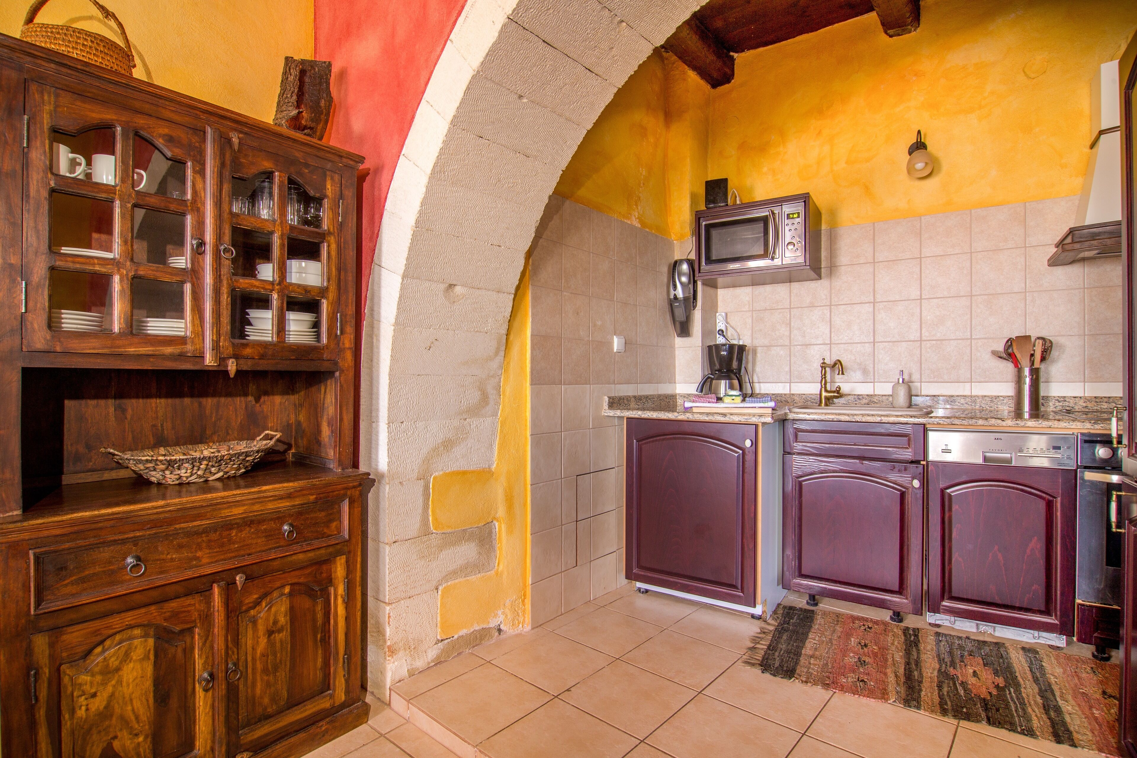 Una cocina con armarios de madera, microondas y pileta.