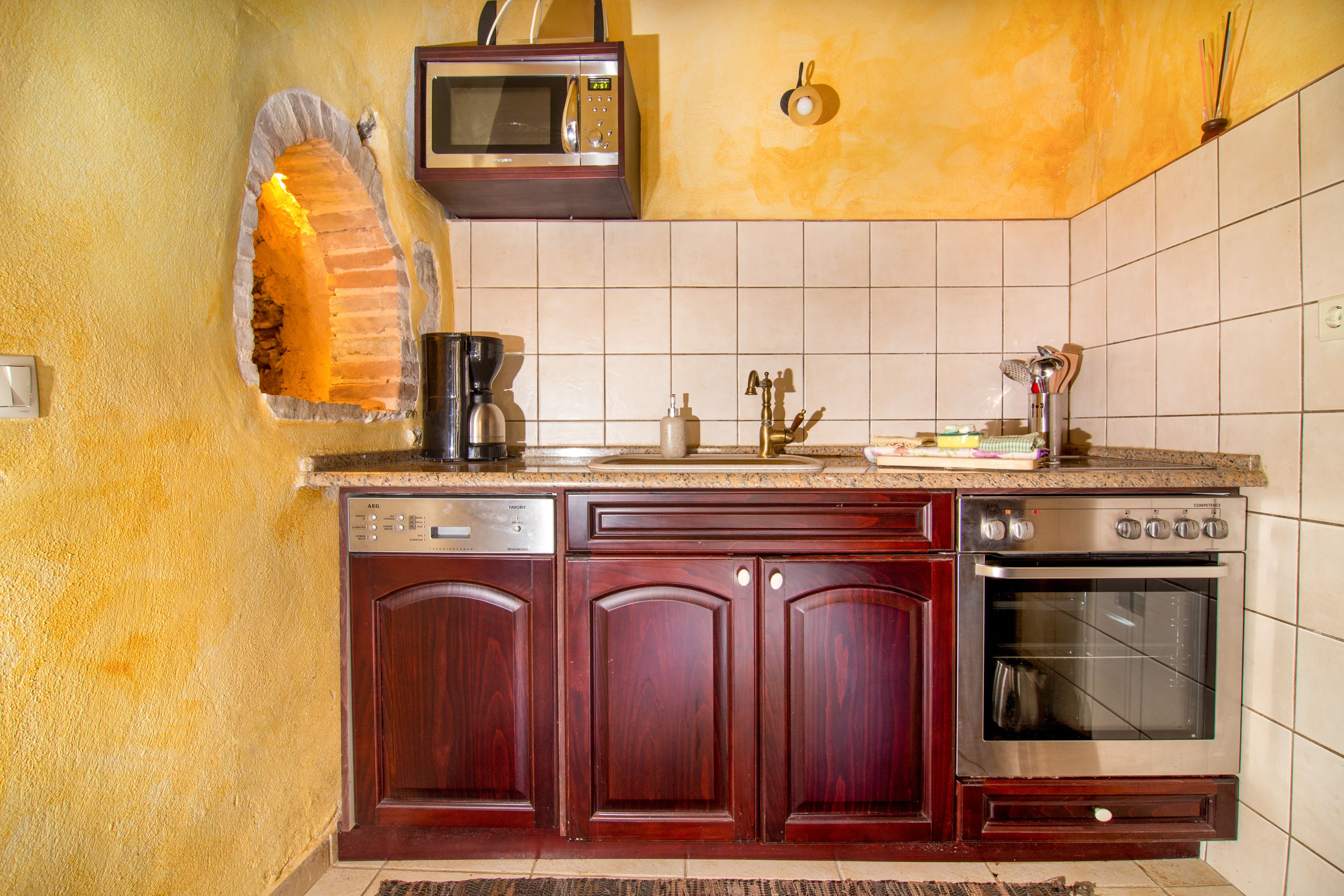 A kitchen with a microwave, stove, and sink.