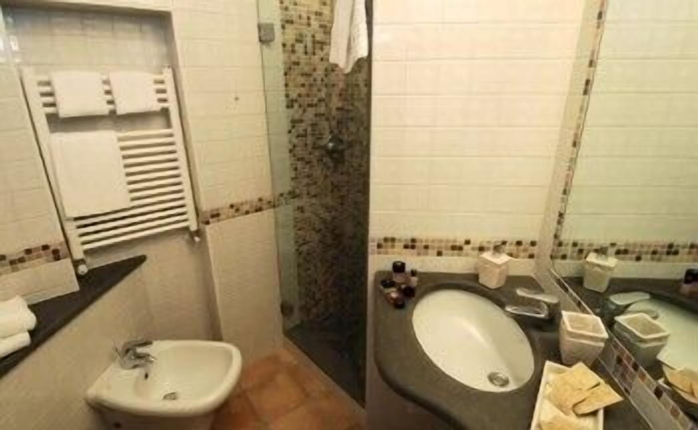 A bathroom with a bidet, a sink, and a mirror.