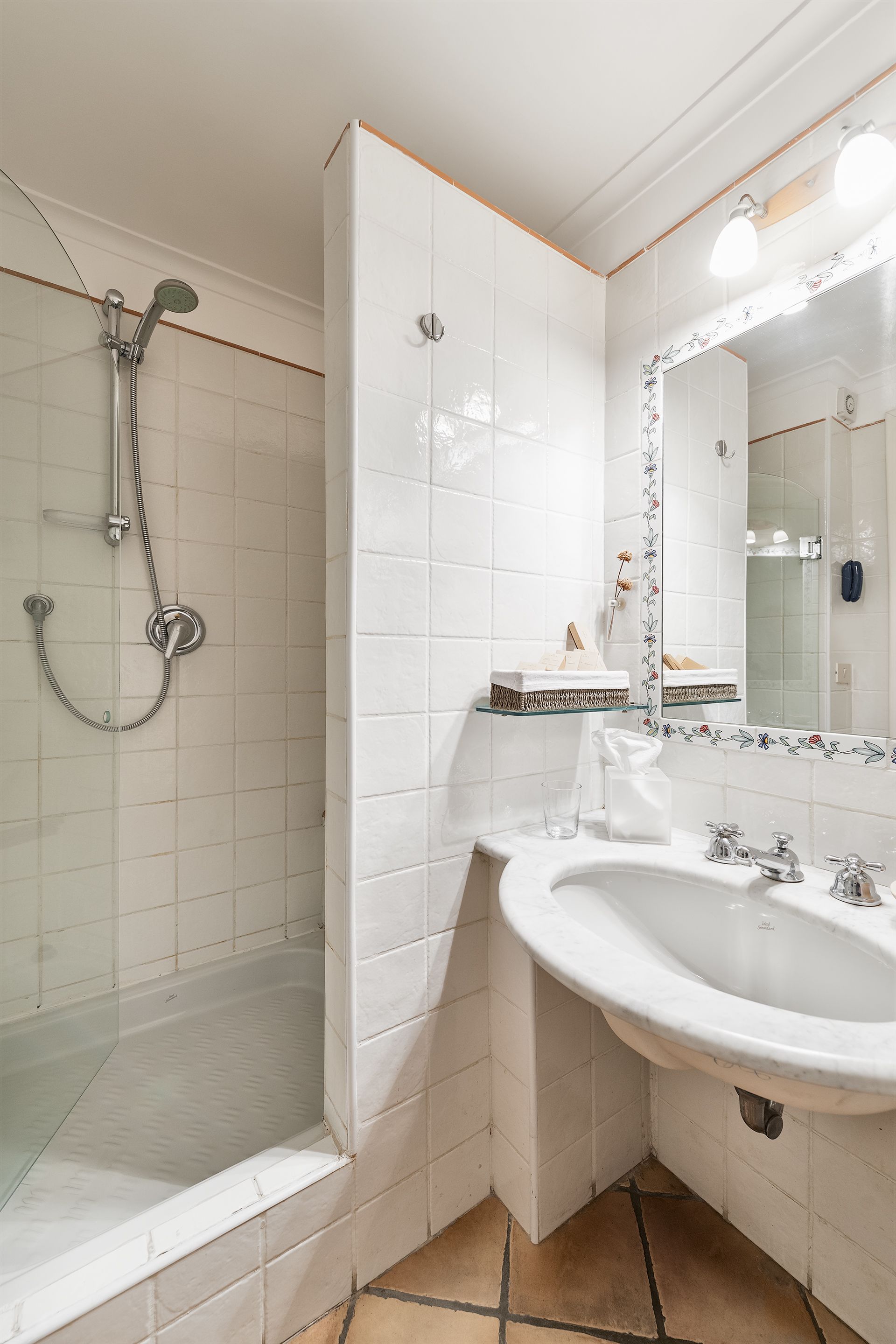 Une salle de bain avec une douche, un lavabo et un miroir.