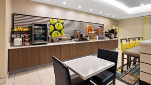 Una cafetería moderna con mostrador, zona de estar y una pared con un cartel.
