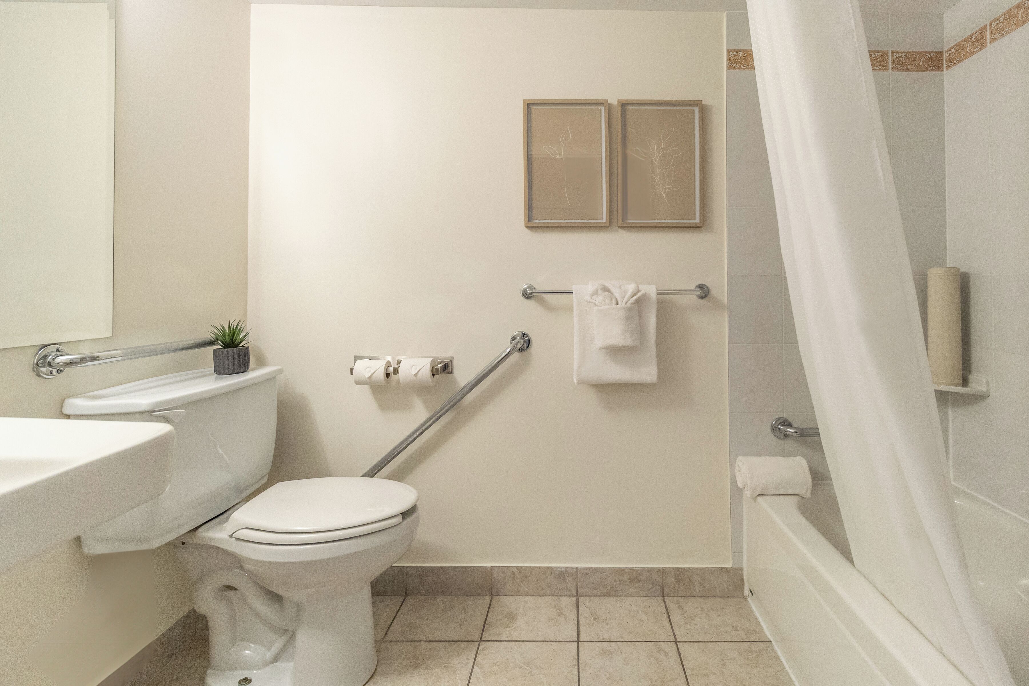 A bathroom with a toilet, sink, and shower area.