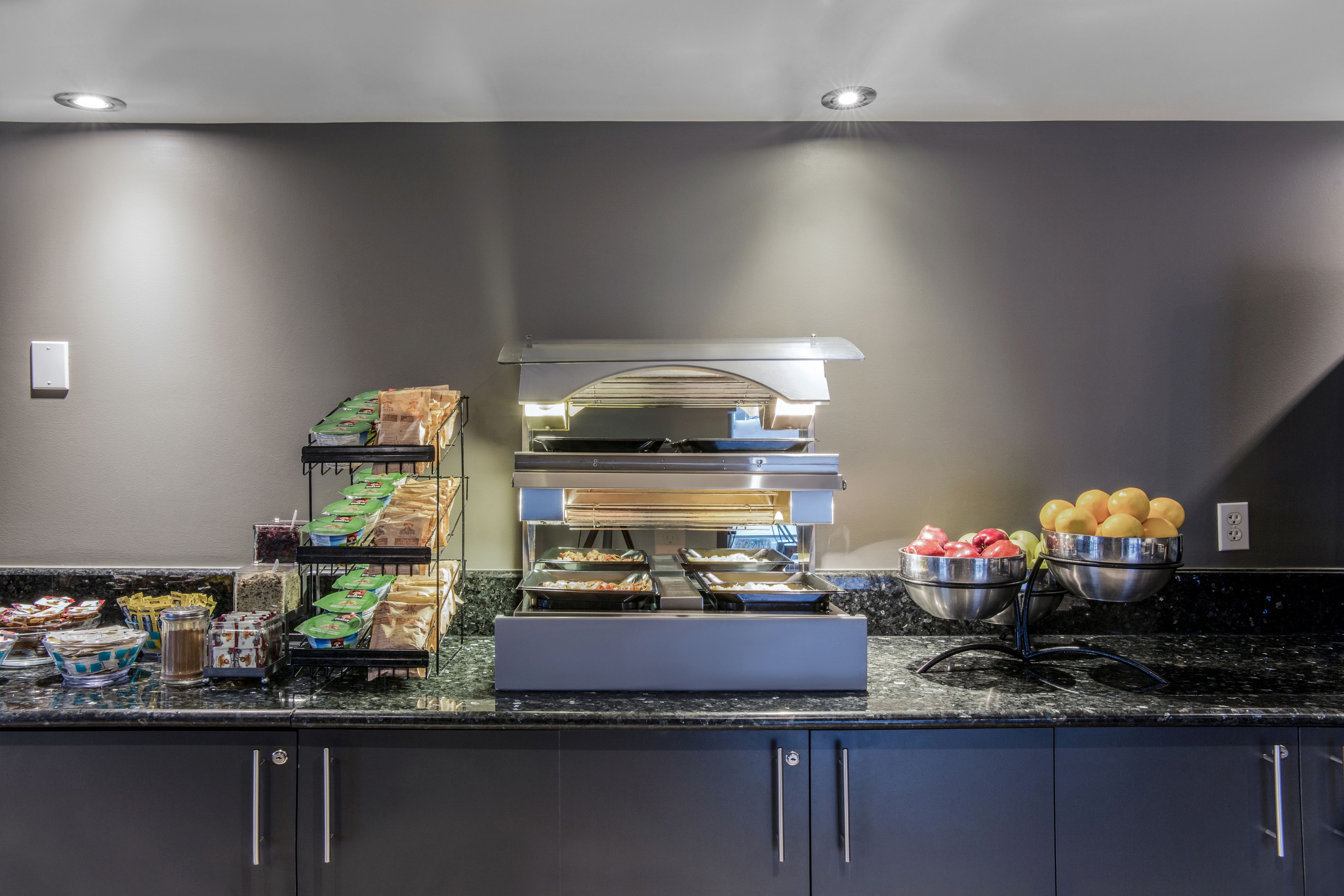 A buffet setup with various food items and a self-service station.