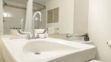 A bathroom with a white sink, a mirror, a towel rack, and a toilet.