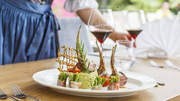 Un plato de comida con diversos ingredientes y una copa de vino tinto.