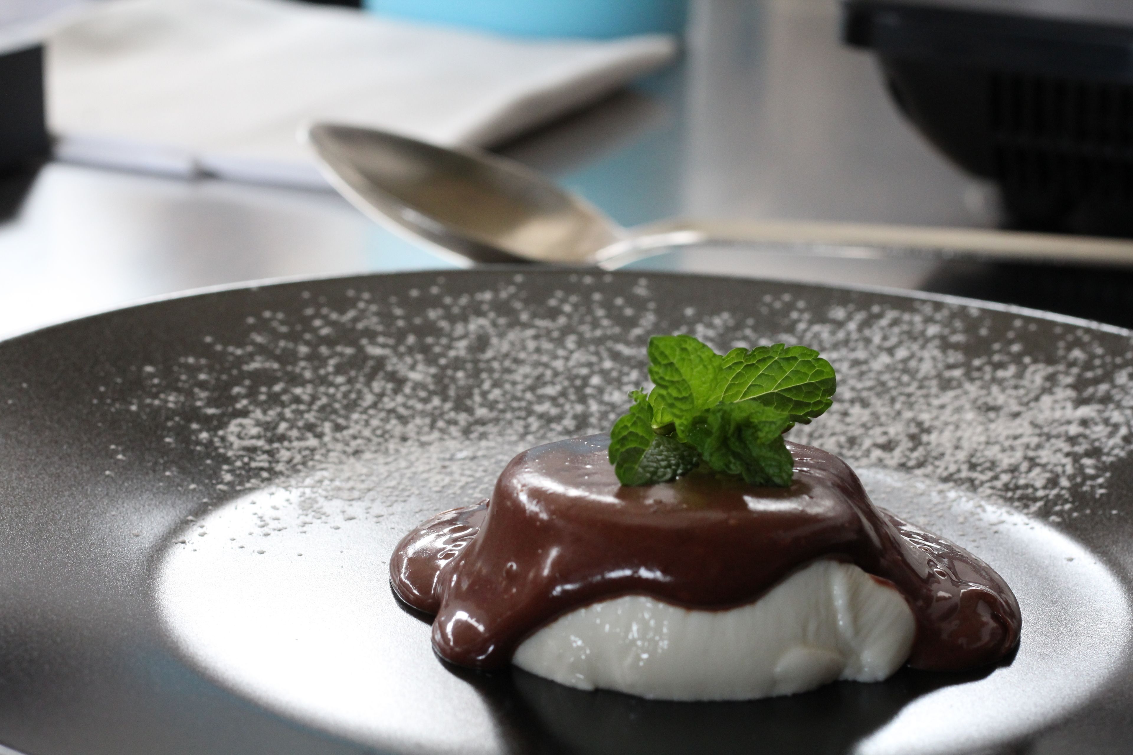 A dessert on a plate with a mint leaf garnish.
