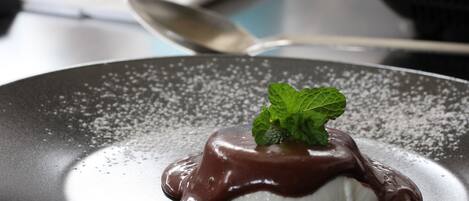A dessert on a plate with a mint leaf garnish.