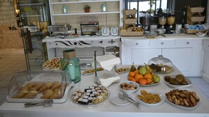 A buffet with various food items including fruits, pastries, and bread. - Hotel Puntaquattroventi (Ercolano)