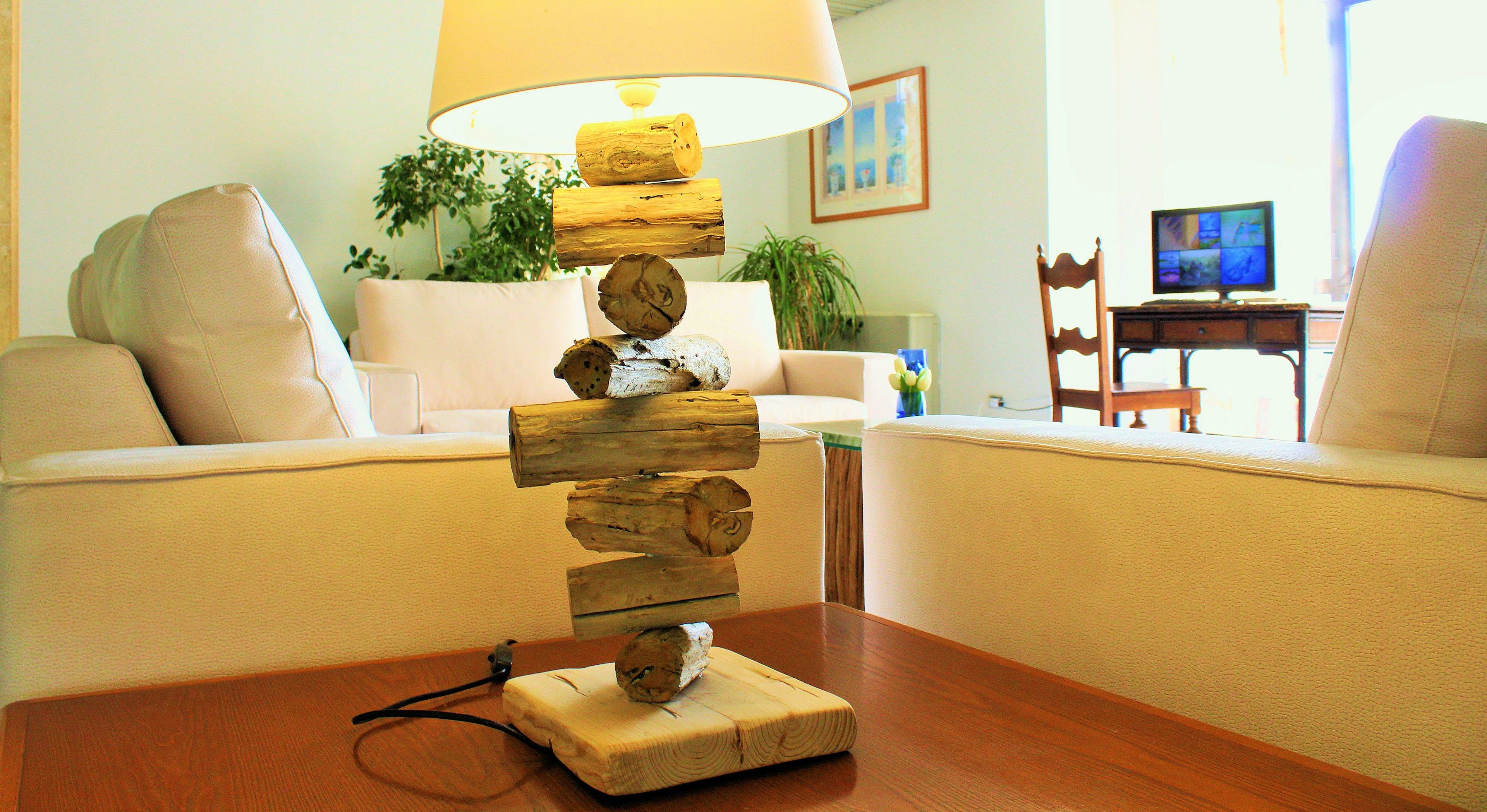 A living room with a wooden sculpture centerpiece, a lamp, and a television in the background.