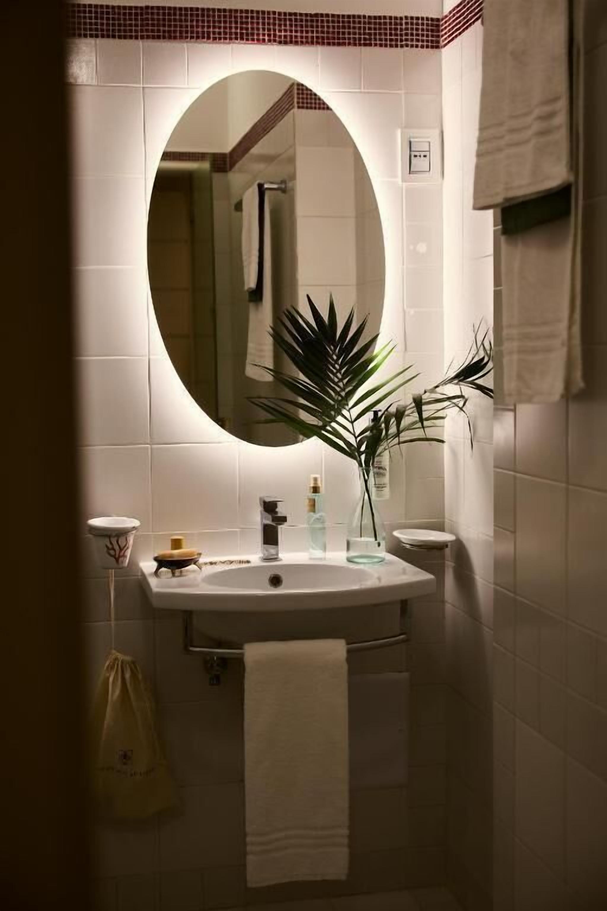 A bathroom with a white sink, a mirror, and a towel rack.