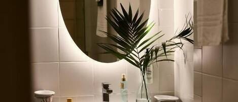 A bathroom with a white sink, a mirror, and a towel rack.