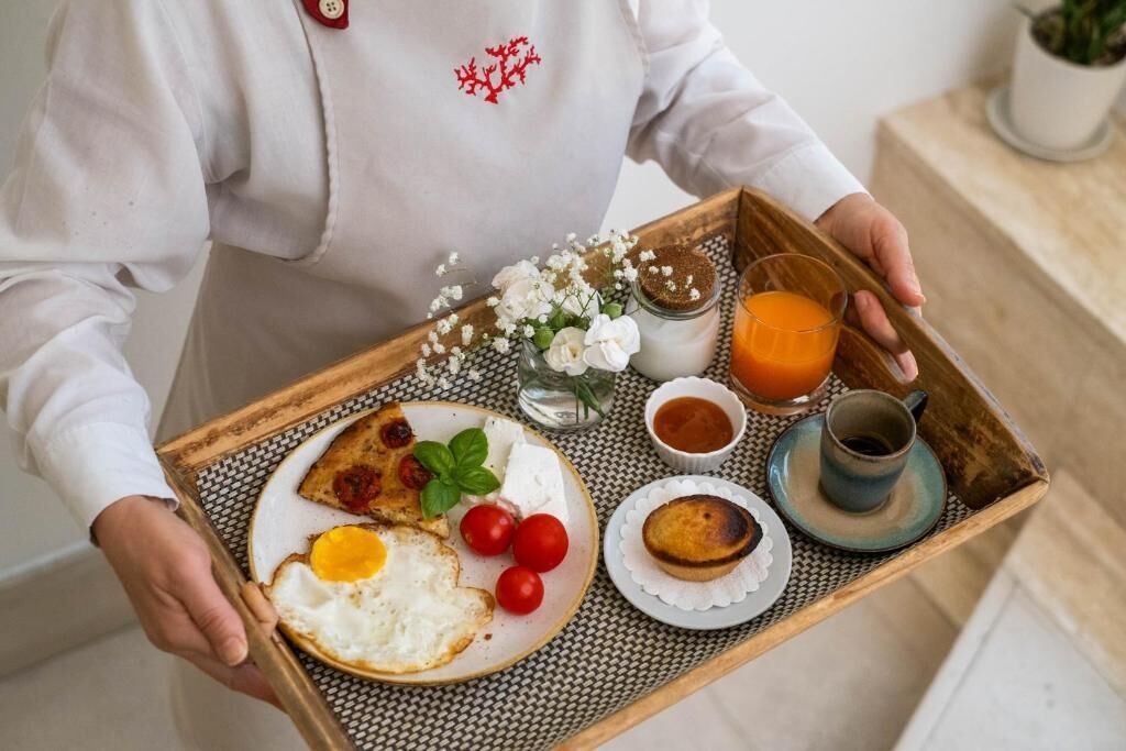 A tray with breakfast items including eggs, tomatoes, and a drink.