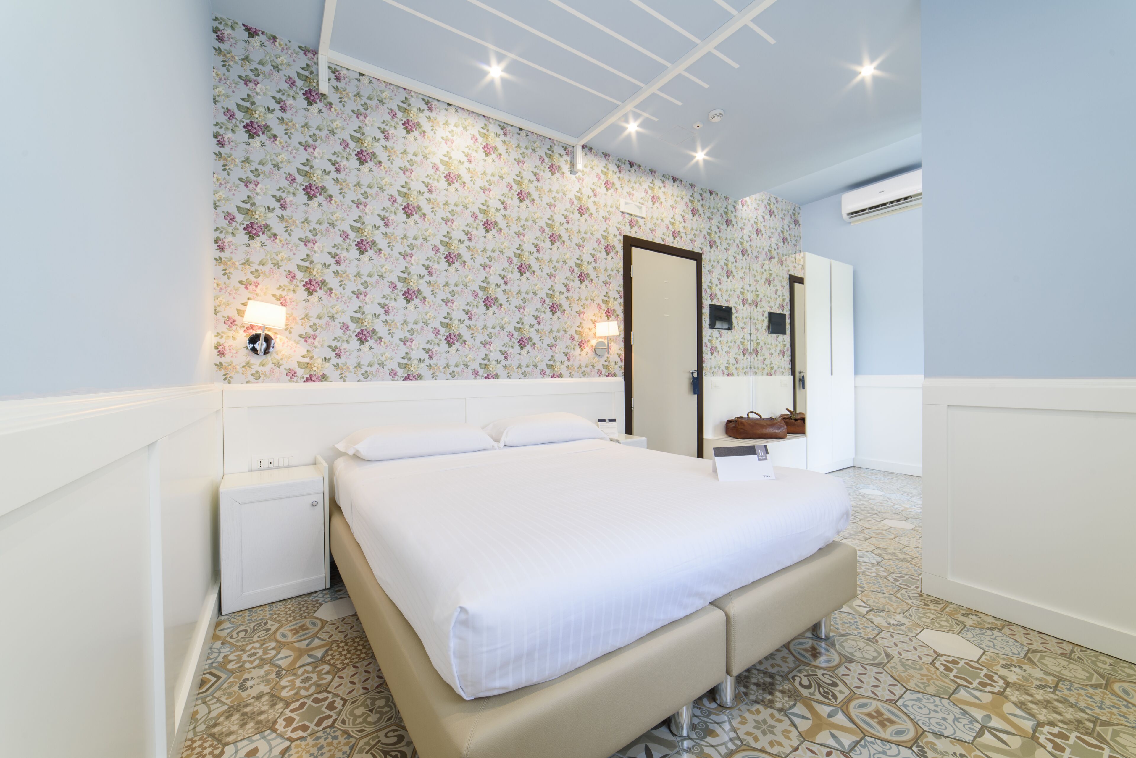 Une chambre à coucher avec un grand lit, une table de chevet, une commode et un miroir.