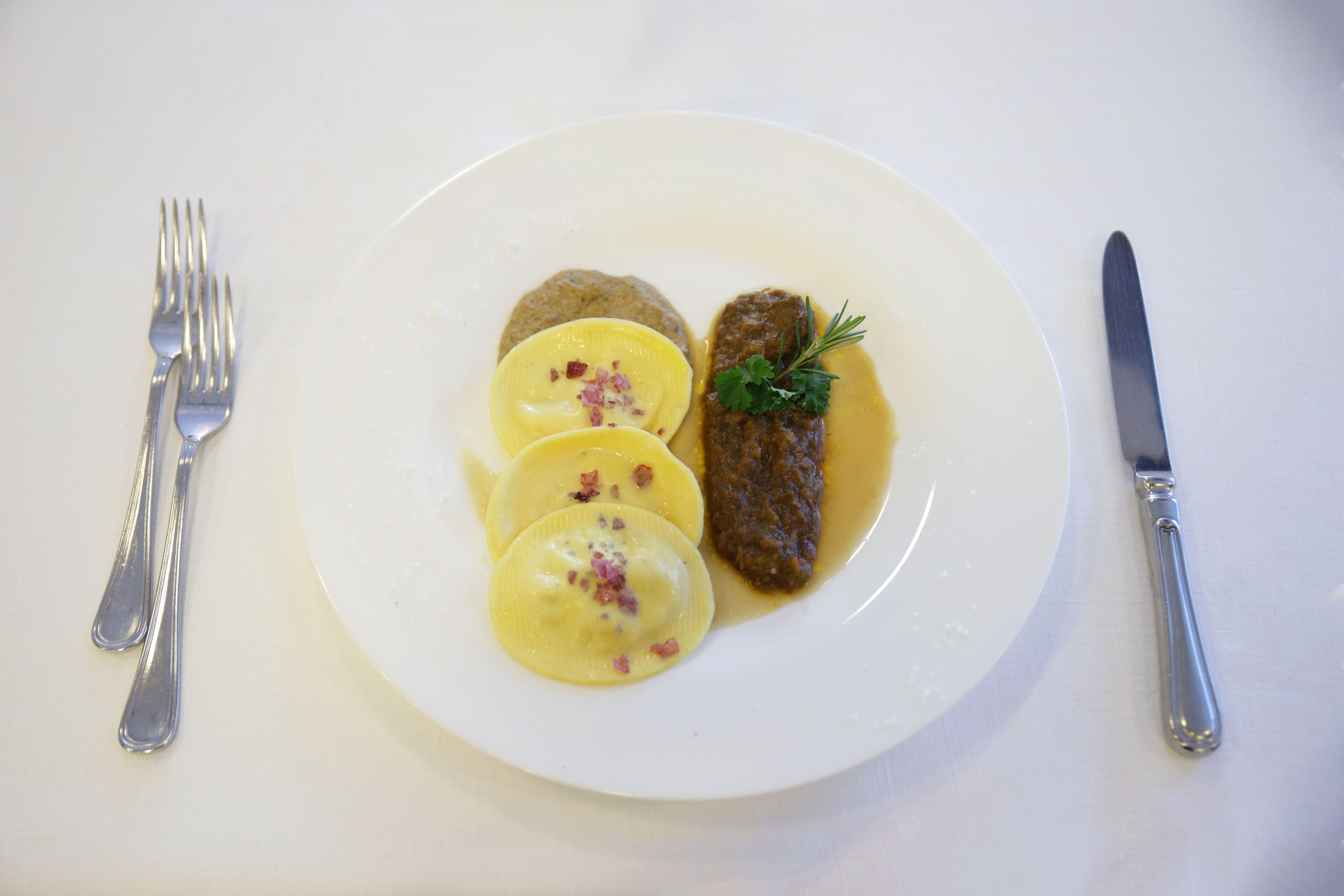 A plate with food, a fork, and a knife on a table.