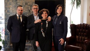 A group of four people standing in a room with a stone wall and a large window. - Hotel Palace (Battipaglia)