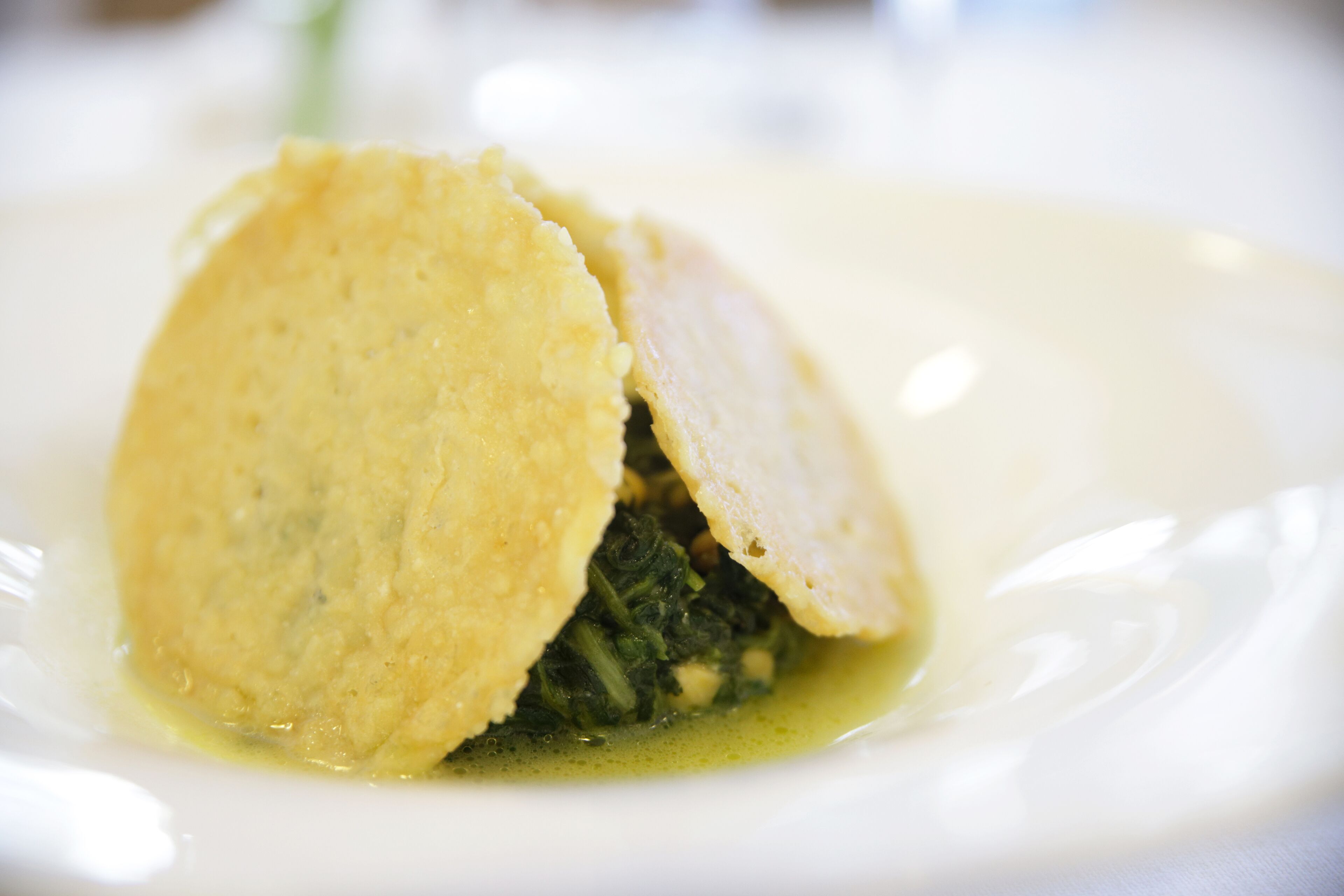A dish with a creamy sauce and greens.
