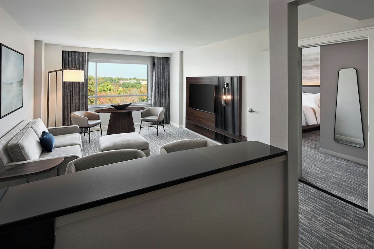 Ein Hotelzimmer mit Essbereich, Fernseher und Blick ins Freie.