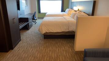 A hotel room with a bed, a desk, a chair, and a TV.