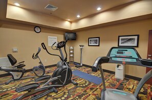 A fitness center with exercise equipment, a clock, and informational signs. - Holiday Inn Express & Suites Altus by IHG (Altus)