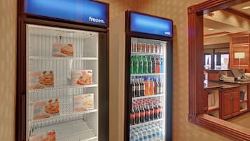 Dos vitrinas refrigeradas, una con la etiqueta 'congelado' y la otra 'frío', contienen diferentes productos alimenticios y bebidas.