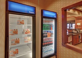 Dos vitrinas refrigeradas, una con la etiqueta 'congelado' y la otra 'frío', contienen diferentes productos alimenticios y bebidas.