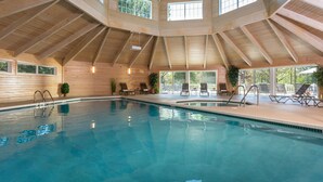 An indoor swimming pool with wooden beams and large windows. - The Ashbrooke (Egg Harbor)