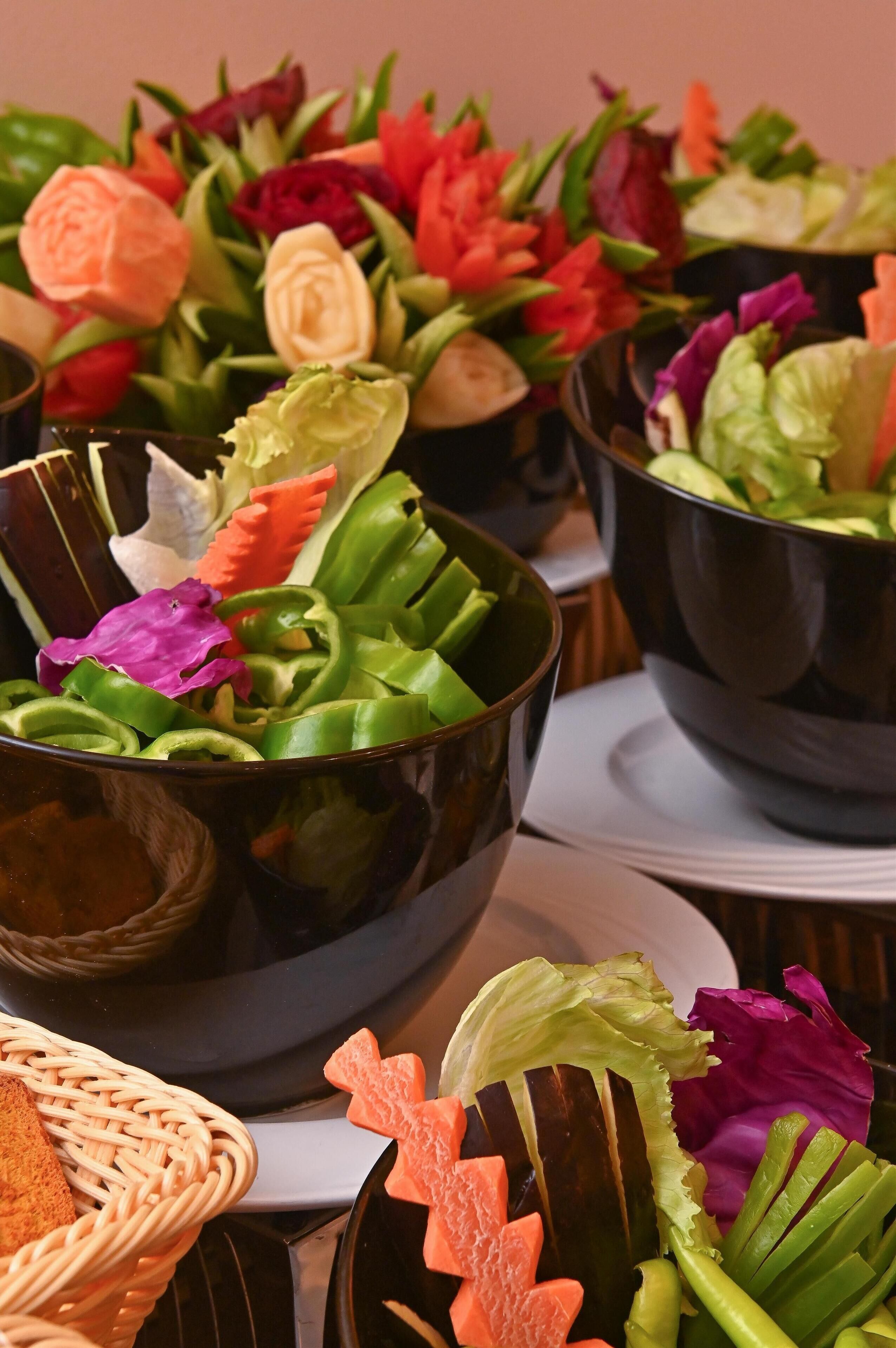 Una mesa con varios recipientes que contienen diferentes verduras y flores.