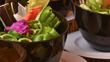 Una mesa con varios recipientes que contienen diferentes verduras y flores.
