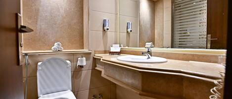 A modern bathroom with a toilet, sink, and mirror.