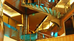 Une structure intérieure à plusieurs niveaux, dotée de rampes et d’escaliers en métal.