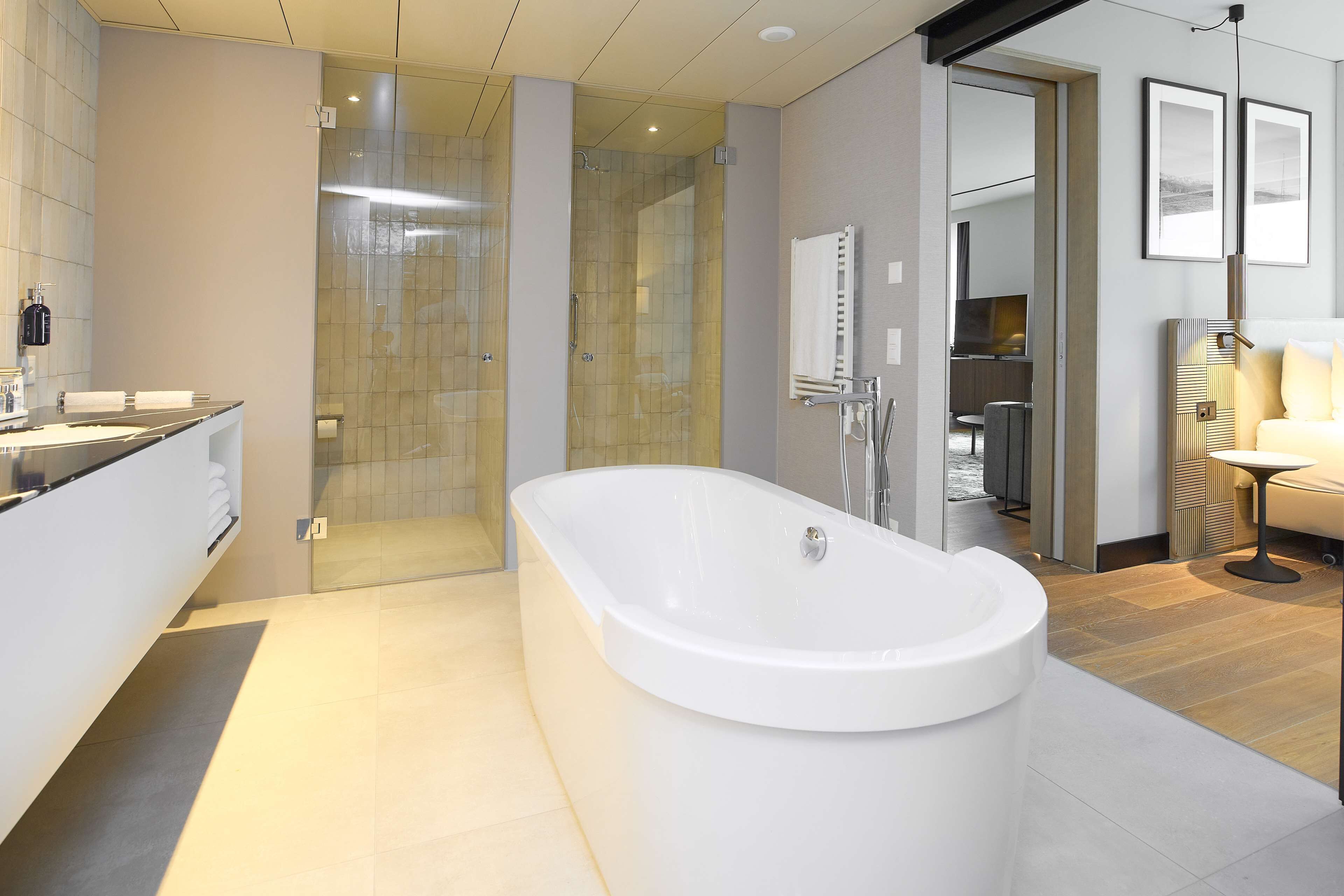 A modern bathroom with a freestanding bathtub, a glass-enclosed shower, and a vanity with a mirror.