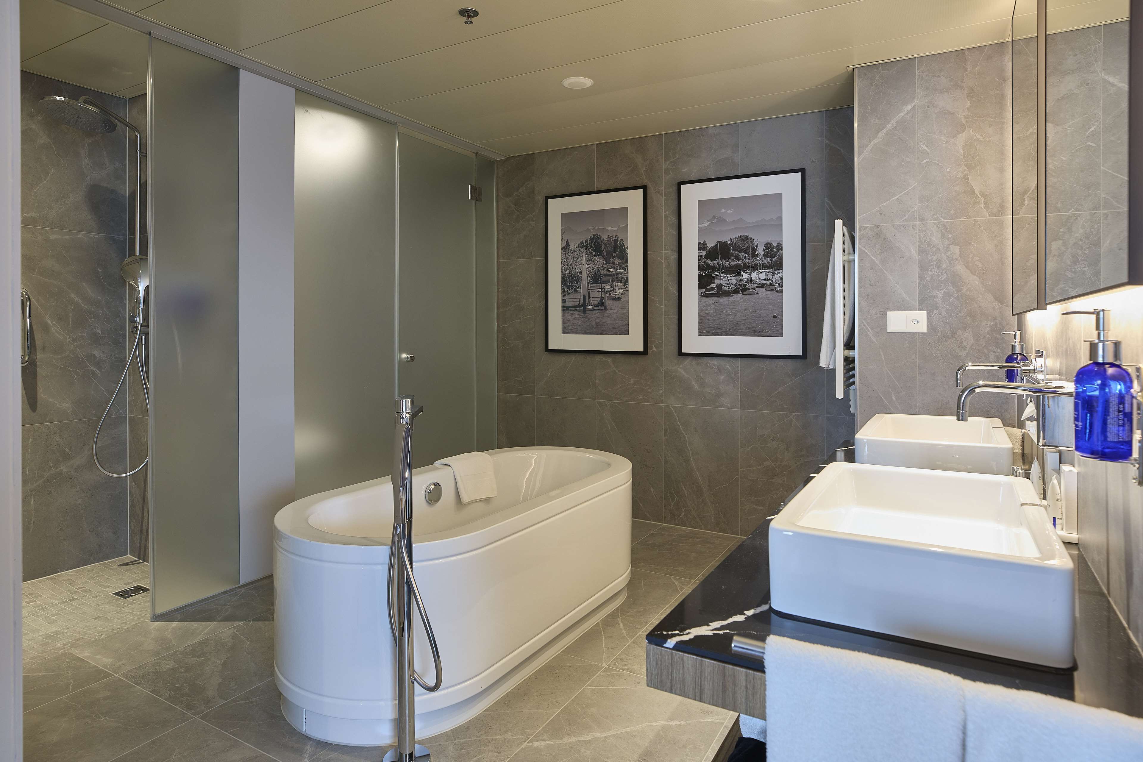 Un baño moderno con una bañera independiente, una ducha a ras de suelo y un lavabo doble.