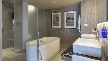 Un baño moderno con una bañera independiente, una ducha a ras de suelo y un lavabo doble.