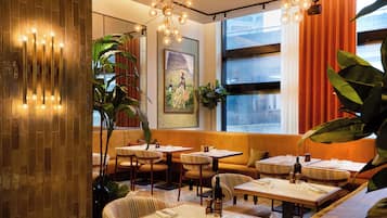 A restaurant interior with booths, tables, and a large window with curtains.