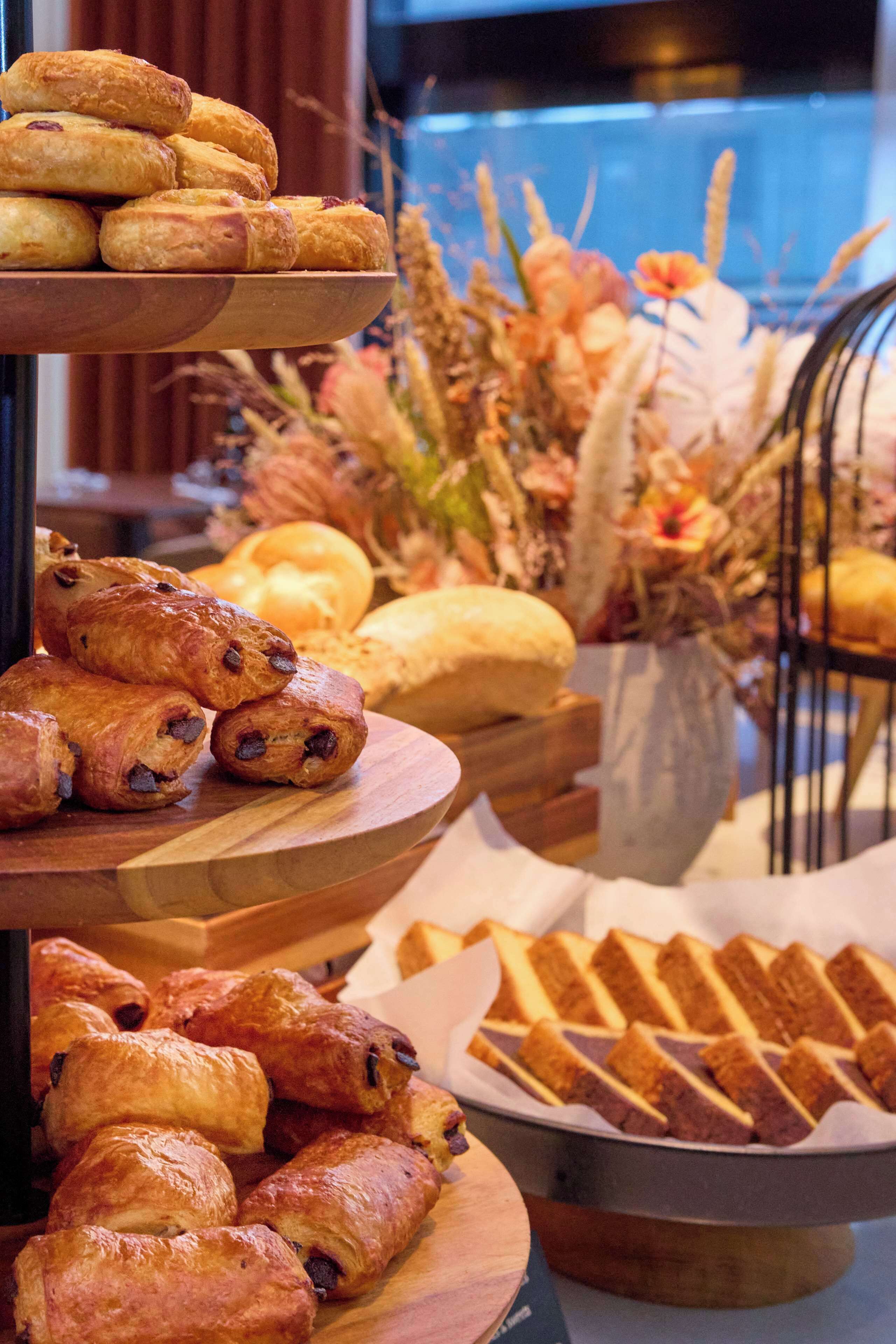 A buffet with various baked goods including pastries and bread.