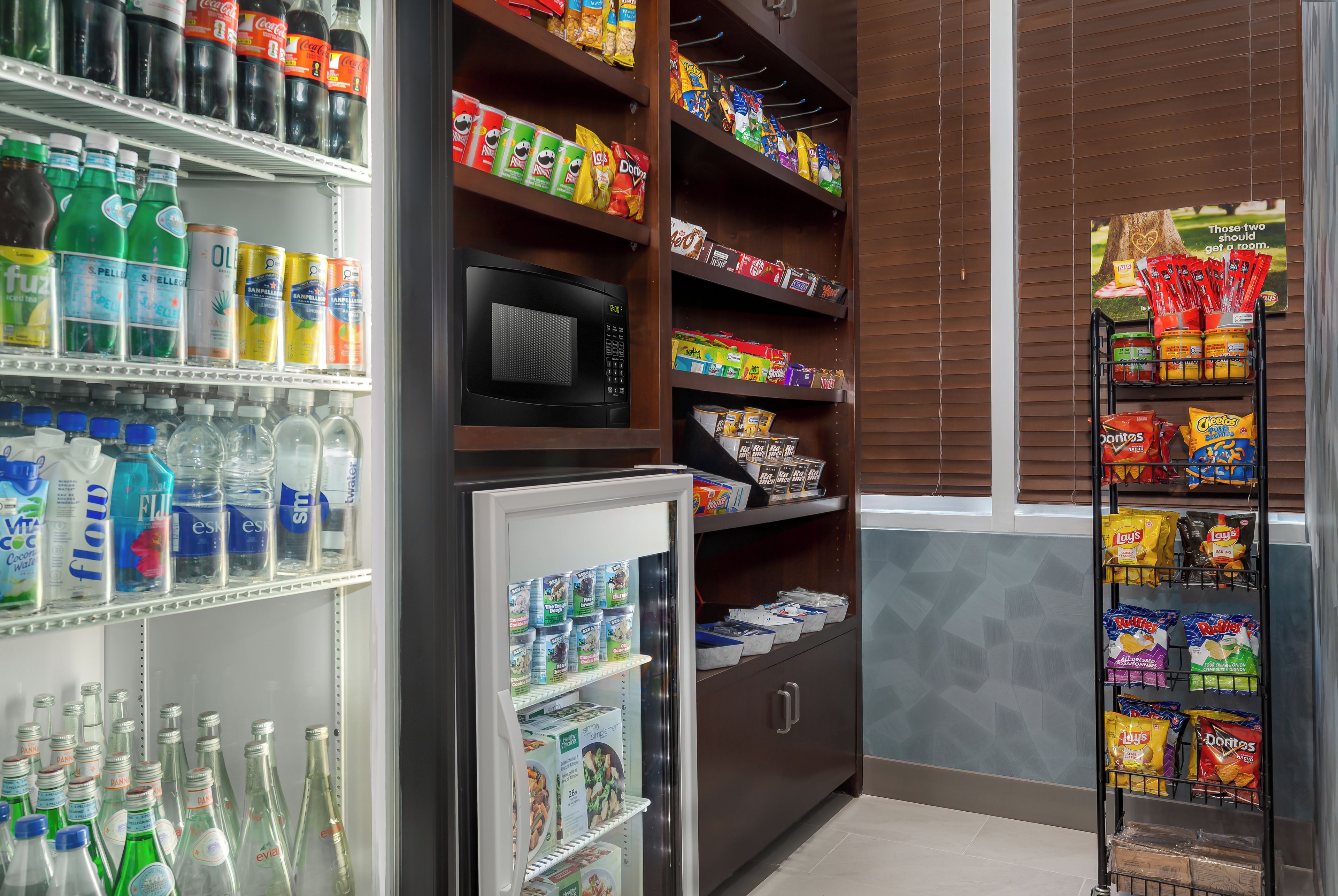 Un espacio con máquinas expendedoras de aperitivos, bebidas y un microondas.