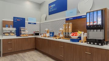 Un comedor para desayunos con estación de autoservicio, área de panadería y exhibición de cereales.