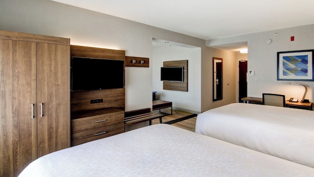 A hotel room with two beds, a wooden wardrobe, a desk, a flat-screen TV, and a framed picture on the wall. - Holiday Inn Express Hotel & Suites Toronto - Markham by IHG (Richmond Hill)
