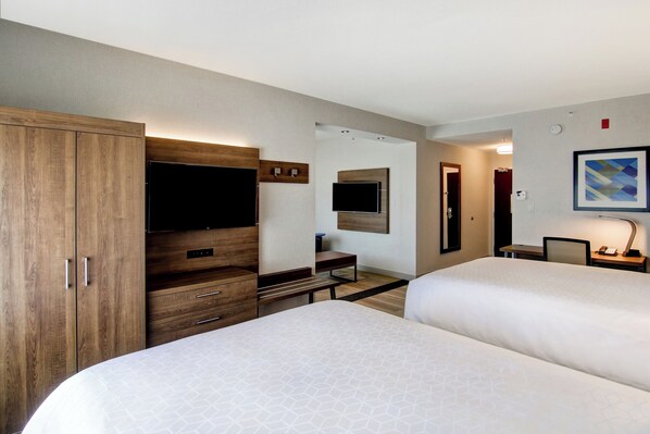 A hotel room with two beds, a wooden wardrobe, a desk, a flat-screen TV, and a framed picture on the wall. - Holiday Inn Express Hotel & Suites Toronto - Markham by IHG (Richmond Hill)