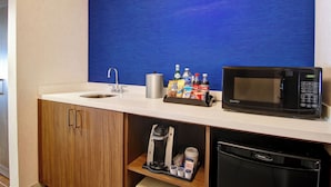 A kitchenette with a microwave, coffee maker, and coffee cups. - Holiday Inn Express Hotel & Suites Toronto - Markham by IHG (Richmond Hill)