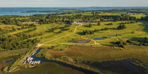 An aerial view of a golf course with multiple greens, water hazards, and a clubhouse. - Glasson LakeHouse (Athlone)