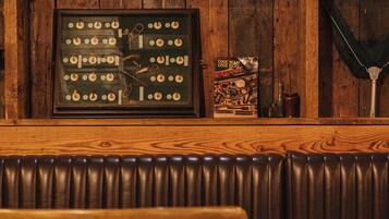 A wooden bar area with a vintage clock, a framed picture of a clock, and a book titled "One Man's Road".