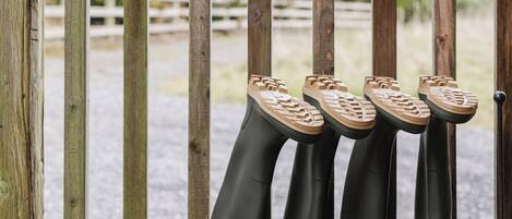 Une rambarde en bois avec un porte-chaussures en métal contenant plusieurs paires de chaussures.