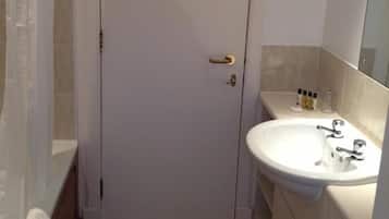 Casa de banho com porta branca, pia e espelho.