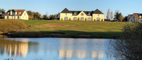 A residential area with houses, a pond, and a golf course.