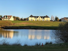 Un barrio residencial con casas, un estanque y un campo de golf.