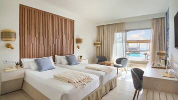 Habitación de hotel con dos camas, un escritorio, una silla, una mesita y vistas a la piscina.